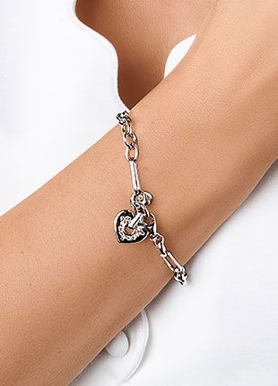 Sterling silver bracelet with heart charm on a ladies wrist. 