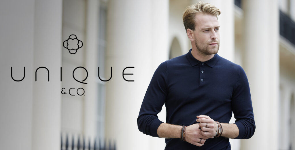 Male model in navy long sleeve polo shirt wearing unique and co leather bracelets