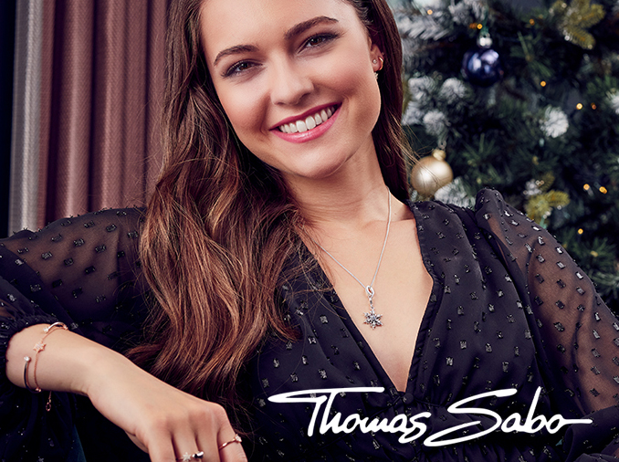 Close up of model smiling at the camera wearing Thomas Sabo jewellery.
